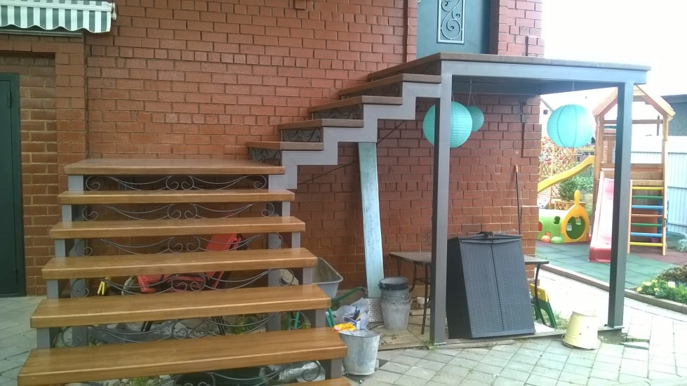 Уличная лестница в дом на металлическом каркасе с поворотом